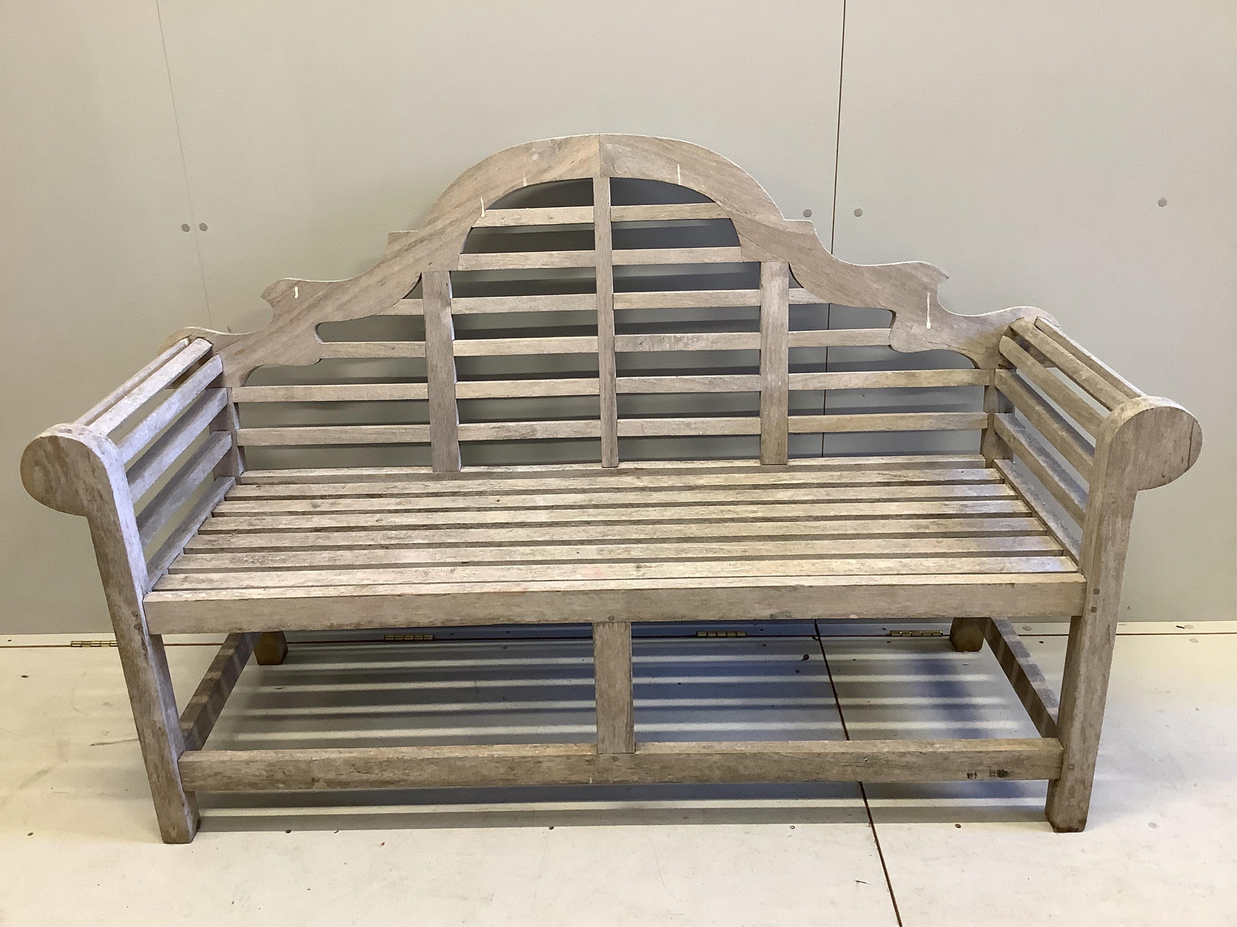 A Lutyens style teak garden bench, width 166cm, and a matching side table, width 80cm. Condition - weathered but otherwise good